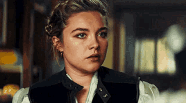 a close up of a woman 's face with a serious look on her face in a room .