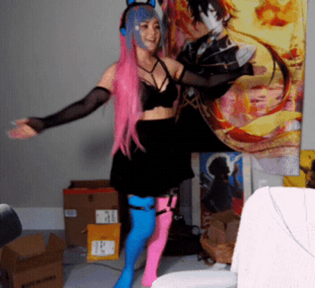a woman in a pink and blue costume stands in front of a wall with a painting of a man on it
