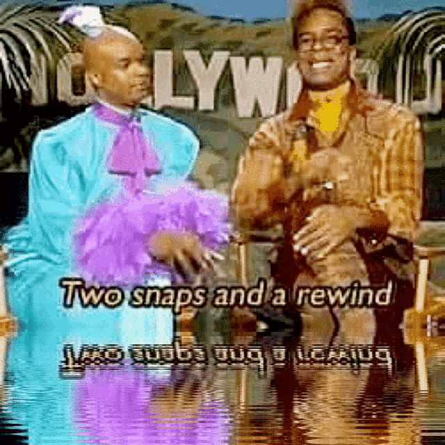 two men are sitting in front of a sign that says " hollywood "