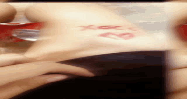 a close up of a person 's hand with a kiss and the word xoxo written on it