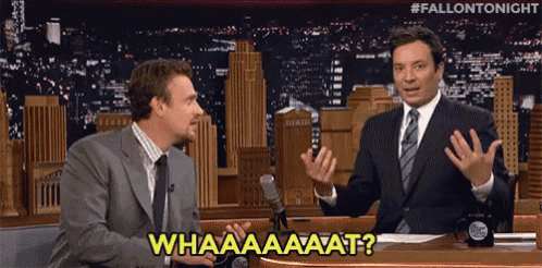 two men are sitting in front of a microphone and one of them is saying " whaaaaaaaat "