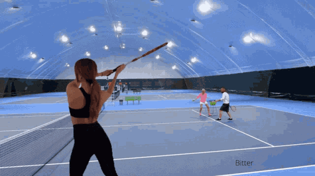 a woman holding a tennis racquet on a tennis court with a sign that says bitter