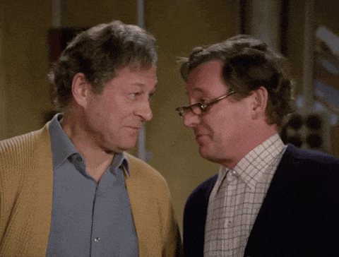 two men are looking at each other and one has glasses