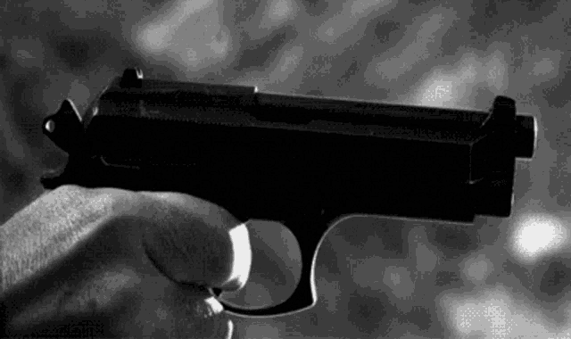 a person is holding a small black gun in their hand