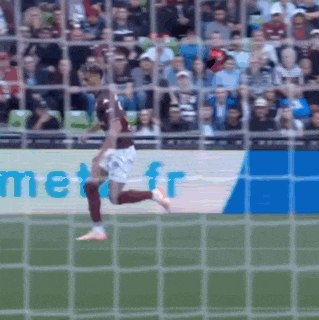a soccer player is running towards a goal with a met.fr banner in the background