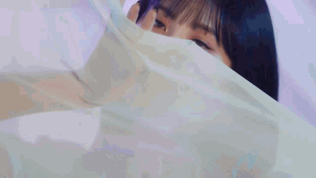 a close up of a woman 's face with a white cloth behind her