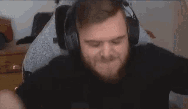 a man wearing headphones is making a funny face while sitting in front of a computer .