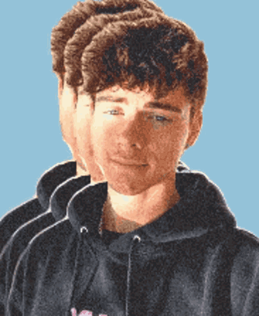 a man with curly hair is wearing a black hoodie with a pink flower on it