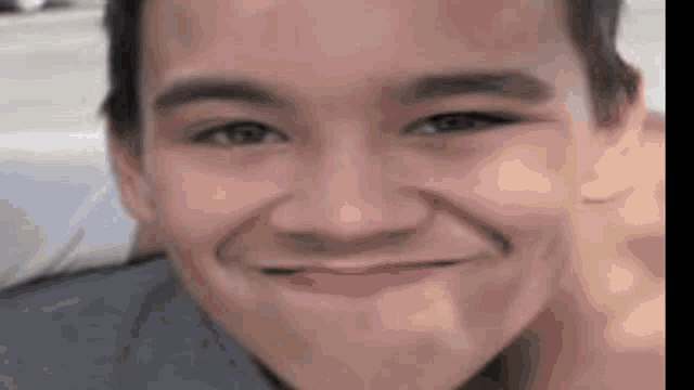 a close up of a young man 's face with a smile on his face .