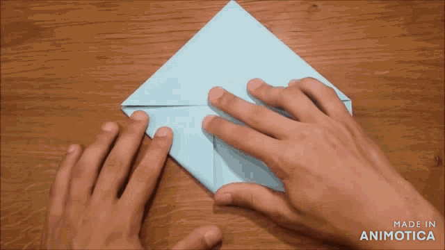 a person folding a piece of paper with the words made in animotica visible