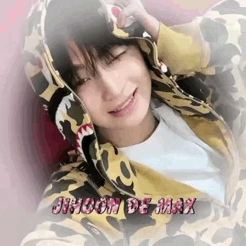 a young man wearing a shark print hoodie is smiling .