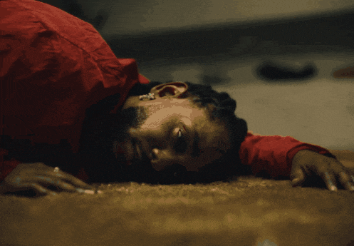 a man in a red shirt is laying on a carpet