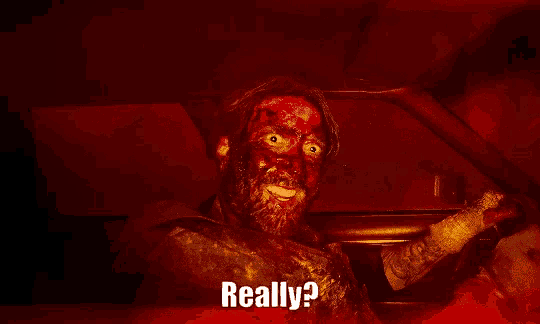 a man with blood on his face is sitting in a car with the words " really " on the bottom