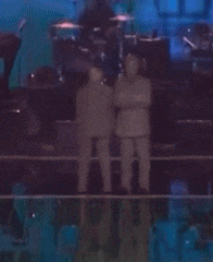 a blurry picture of two men dancing on stage