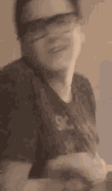 a man wearing sunglasses and a black shirt is making a funny face .