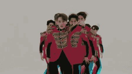 a group of young men are standing next to each other on a white background and dancing .