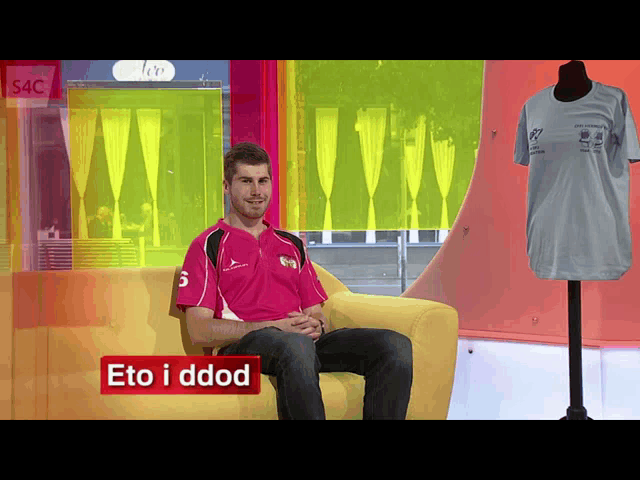 a man in a pink shirt sits on a couch with the words eto i dddd on the bottom