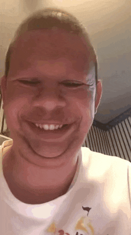 a man is smiling and making a funny face with his mouth open .