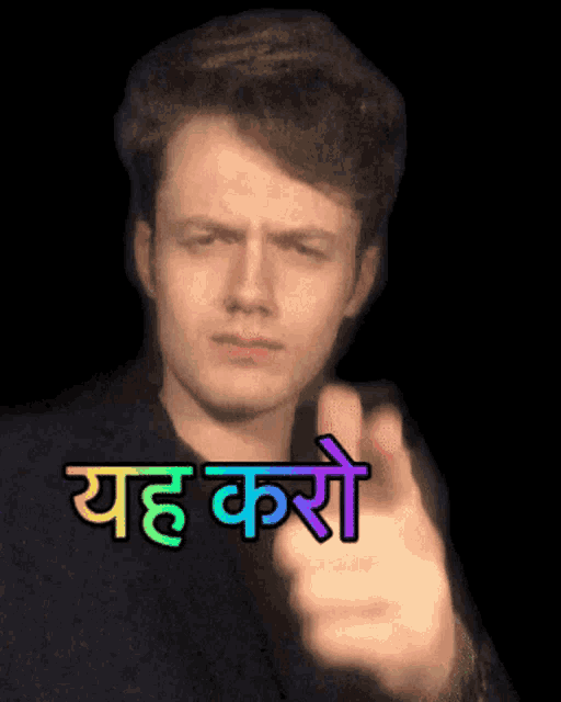 a man is pointing at the camera with a sticker that says yeah karo on it