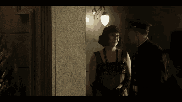 a man and a woman are standing next to each other in front of a building