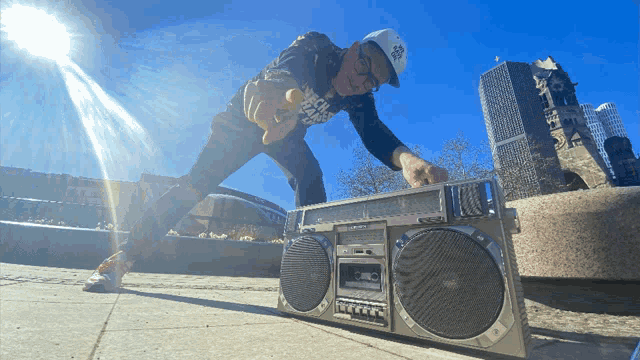 a man wearing a new york yankees hat is playing a boombox