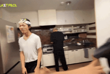 a man in a white shirt is standing in a kitchen with last piece written on the wall above him
