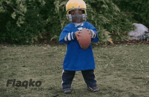 a young boy wearing a helmet and holding a football with flagko written on the bottom right
