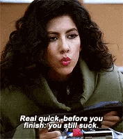 a woman with curly hair is blowing a kiss while holding a cell phone in her hand .