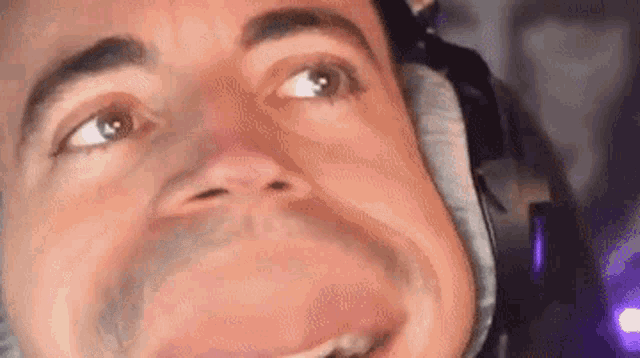a close up of a man 's face with headphones on .