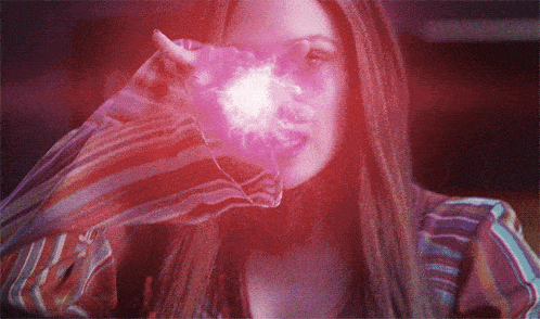 a woman wearing a striped shirt is holding a purple object in her hand