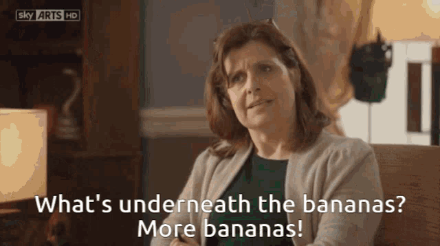 a woman sitting in a chair with the words what 's underneath the bananas more bananas written below her