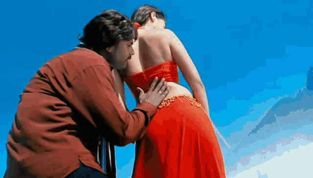 a man is touching a woman 's butt in a red dress