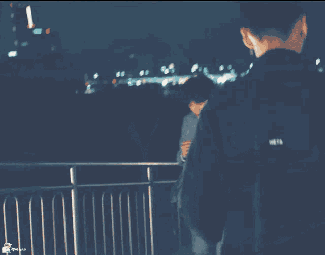 a man in a suit and tie is standing on a balcony