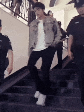 a man is walking up a set of stairs with a group of people behind him .