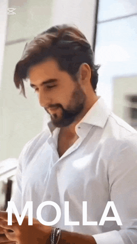 a man with a beard is wearing a white shirt with the word molla on the bottom
