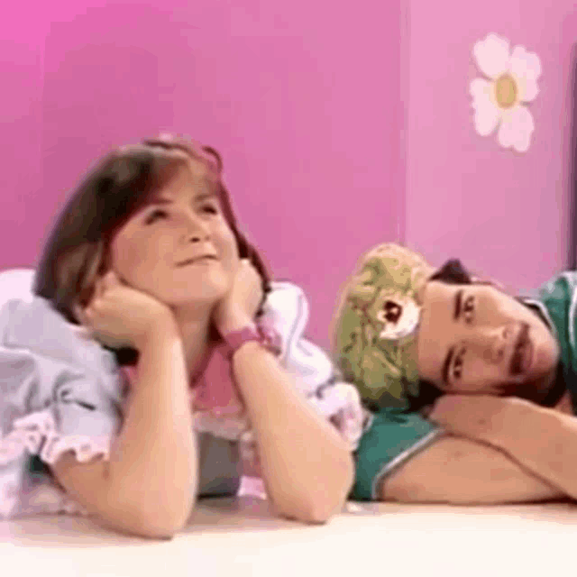 a man and a woman are laying on a bed and looking up at the sky .