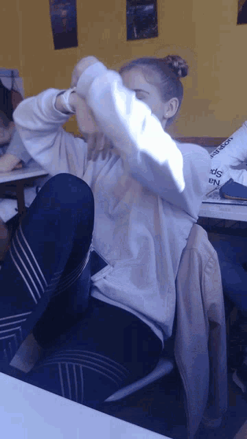 a girl wearing a white sweatshirt with the word adidas on it