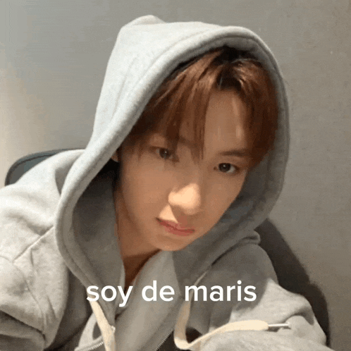 a young man wearing a grey hoodie with the word soy de maris on the bottom