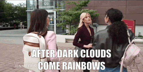 three women are standing in front of a building with the words after dark clouds come rainbows on the bottom