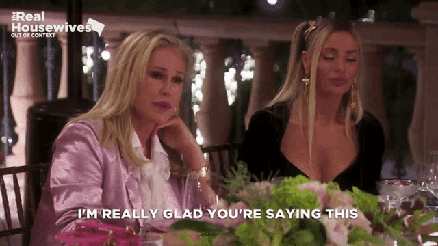two women sitting at a table with the words i 'm really glad you 're saying this on the bottom
