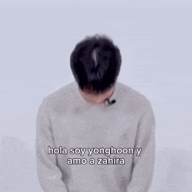 a young man wearing a grey sweater says hola soy yonghoon y amo a zahira in spanish