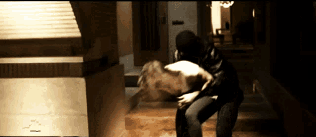 a man in a black mask is carrying a woman in his arms