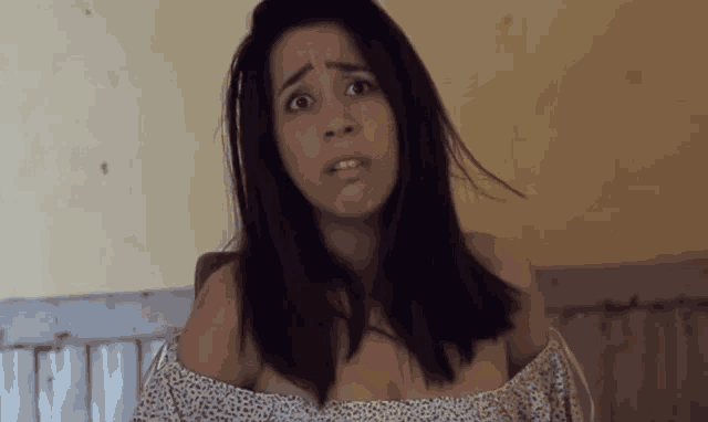 a woman with a leopard print off the shoulder top is making a face