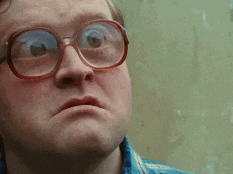 a close up of a man wearing glasses and making a face