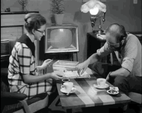 a man and a woman are sitting at a table playing a game