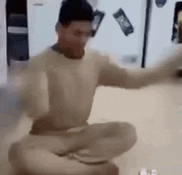 a man is sitting on the floor in a kitchen .