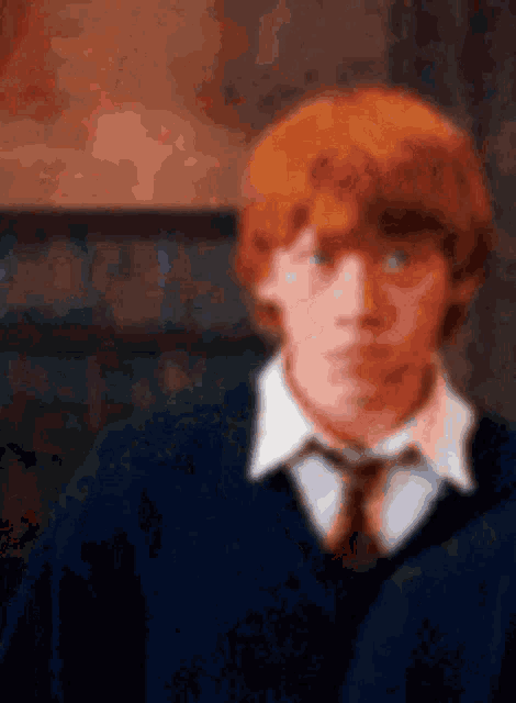 a blurry picture of a man with red hair wearing a blue shirt and tie