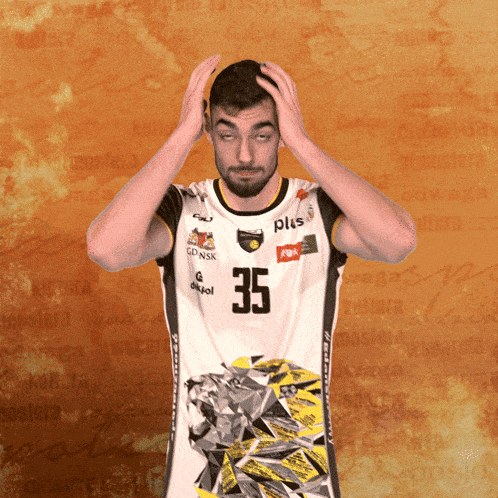 a man wearing a number 35 jersey holds his head