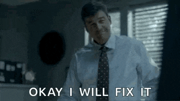 a man in a suit and tie is standing in front of a window .