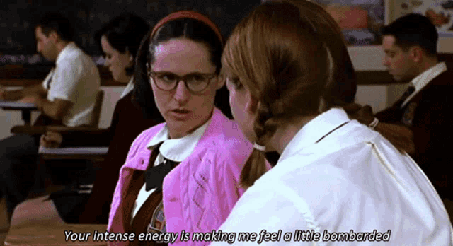 a girl in a pink sweater says " your intense energy is making me feel a little bombarded " in a classroom